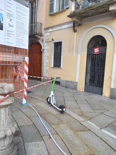 A tape delineating a construction site... only that it uses an electric scooter from a local sharing service as a pole